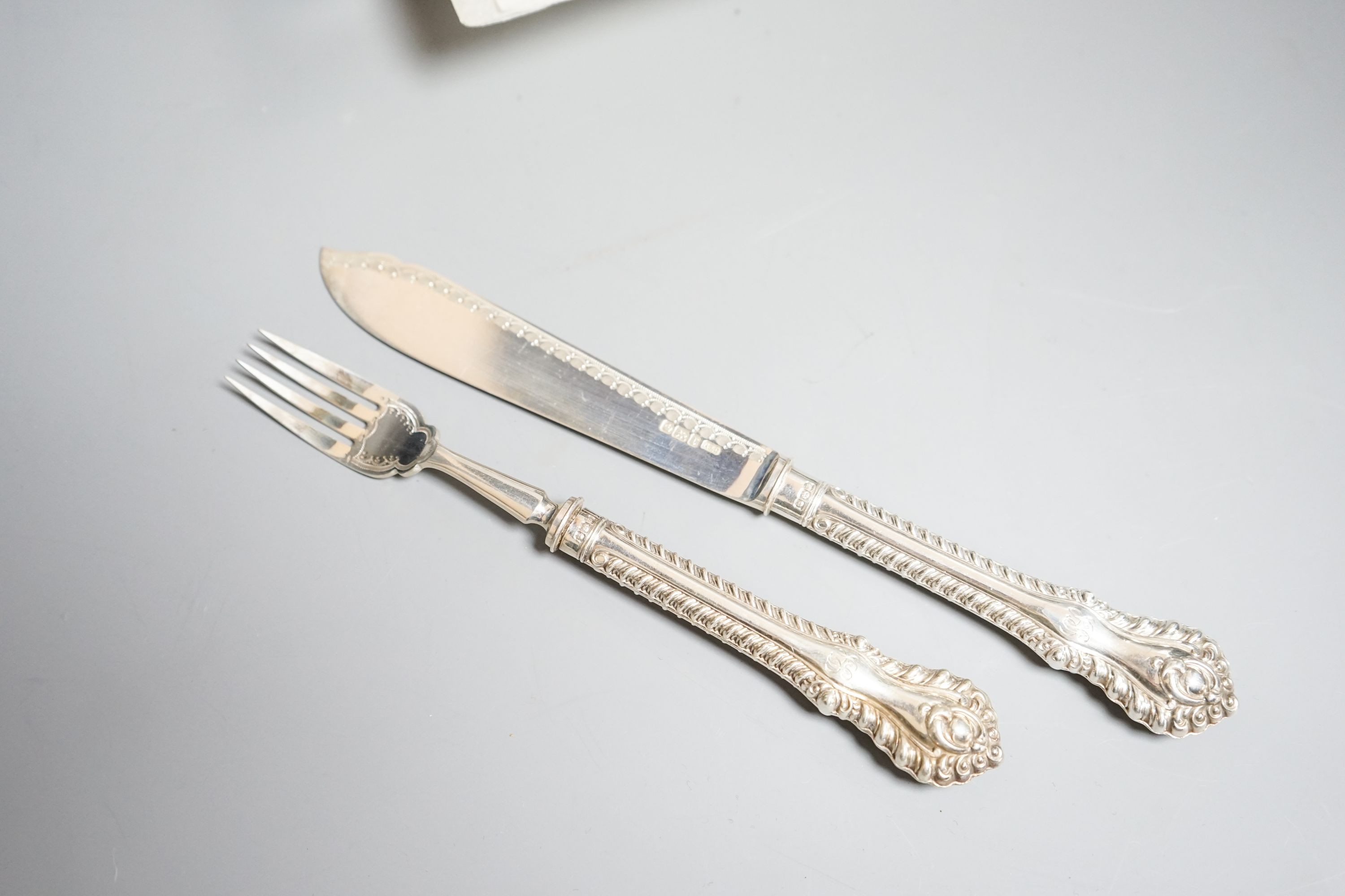 A cased set of twelve pairs of Edwardian silver fish eaters, Allen & Darwin, Sheffield, 1909 (loaded handles)